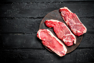 Raw beef steaks on cutting Board.