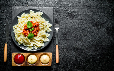 Farfalle pasta with mint leaves and different sauces.