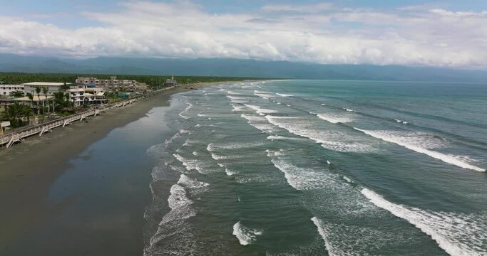 Top view of coast with hotels and tourists, a famous place for surfing in the Philippines. Sabang Beach, Baler, Aurora, Philippines.