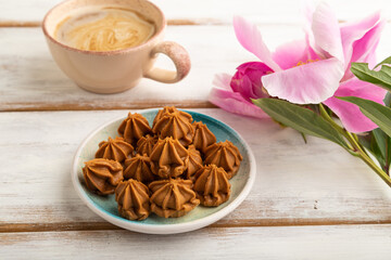 Homemade soft caramel fudge candies on white wooden, side view, close up.