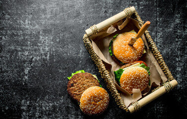 Burgers in a basket with a knife.