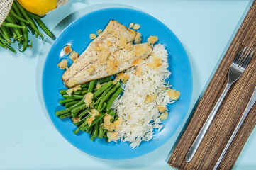 Lebanese-style fried fish on a serving dish with onion flavoured rice and roasted almond slivers.