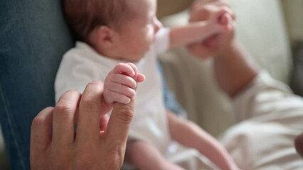 Baby grasping finger of father
