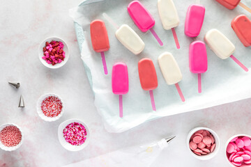 undecorated cake pops with various sprinkles and candy melts all around.