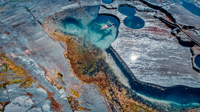 Aerial Side View of Girl Floating in Famous Figure 8 Pools In Royal National Park, Australia