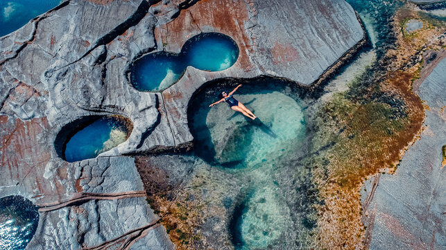 Drone View of Girl Floating in Famous Figure 8 Pools In Royal National Park, Australia