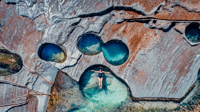 Aerial of Girl Floating in Famous Figure 8 Pools In Royal National Park, Australia