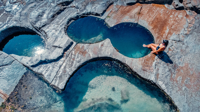 Girl Sitting At Edge of Famous Figure 8 Pool In Royal National Park, Australia