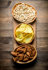 Peanuts, chips and crumbs in the bowls.