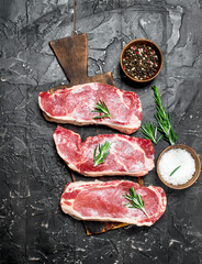 Raw marbled beef steaks with salt and spices.