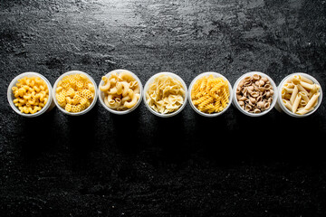 Variety of dry pasta in bowls.