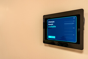 Close up image of a meeting room reservation system screen that is integrated into a smart...
