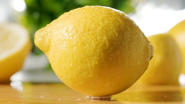 Fresh lemon falling on wooden table, Slow motion shot, Blurred lemons in Background