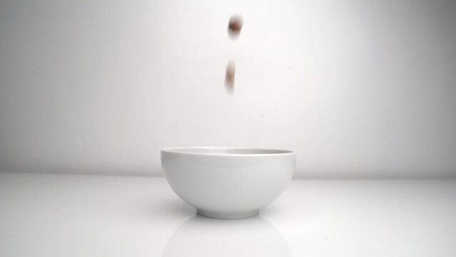 Pouring Cereal Into A Bowl On White Backdrop