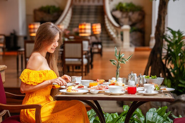 Woman Enjoying breakfast meal in Luxury Restaurant in modern resort or hotel