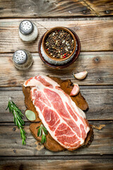 Raw pork steak with spices .