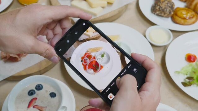 Man Taking Photo of Delicious smoked salmon Food with Mobile Phone