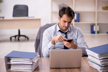 Young male employee and too much work in the office