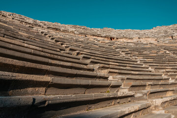 The seats of the ancient amphitheater against the blue sky on a sunny day.