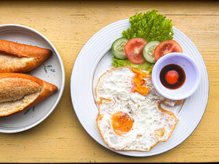 Fried egg type food eaten with fresh vegetables.