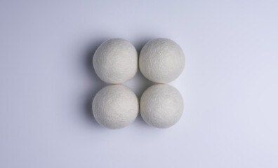 Four white wool dryer balls