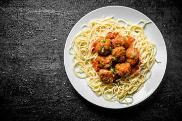 Spaghetti with meat balls on a plate.