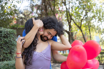 Young Mexican man surprises his girlfriend in the park by covering her eyes on Valentine's Day