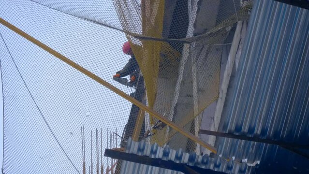 Construction site, where a modern beautiful multi-storey building is being erected by casting a monolith into a formwork reinforced with metal reinforcement. The builder makes a hole in the slab