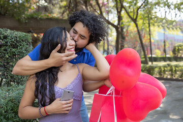Young Mexican man surprises his girlfriend in the park by covering her eyes on Valentine's Day