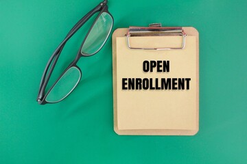 glasses and paper with the word Open Enrollment. open enrollment concept. student registration