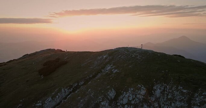 Drone shot of the top of mountain Peca at the sunrise in the morning, hiker walking on the ridge of the mountain.Some clouds on the sky.