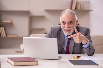 Old male employee working from home during pandemic