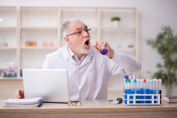 Old male chemist working at the lab