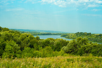 Summer countryside view with river and forest.
