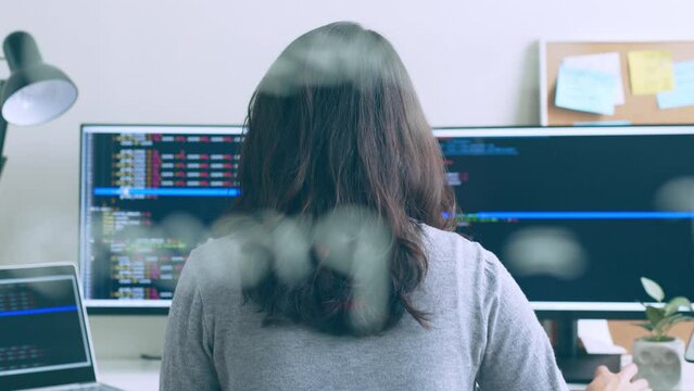 Young Asian woman, developer programmer, software engineer, IT support, working hard on computer to check coding in bugging system