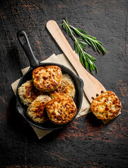 Cutlets in the pan on the paper with a wooden spatula.