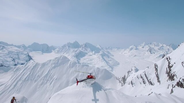 Heli-Skiing helicopter perched on top of a snowy mountain in Alaska