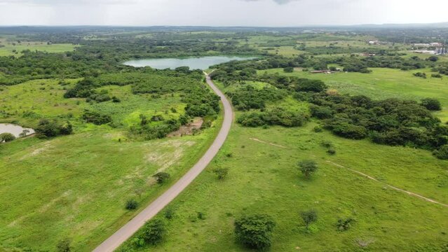 Autopista en el llano con arboles y lago
