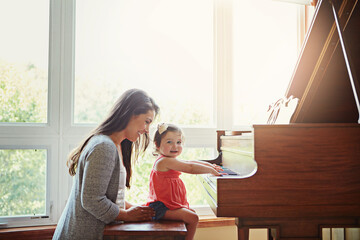 Playing, music and mother and child with a piano, learning and happy together in a house. Love, smile and portrait of a playful baby with her fun mom teaching to play an instrument for happiness