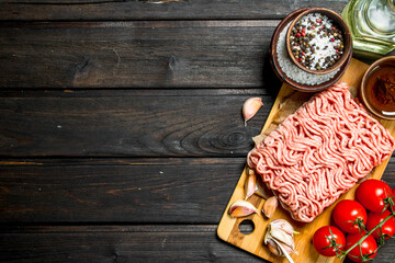 Raw ground beef with tomatoes and spices.
