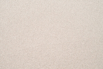 Background with coastal sand. A well-groomed shore with clean yellow sand.