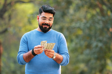 Young indian man counting money