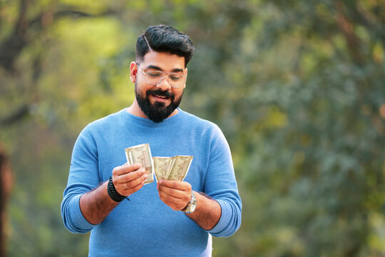 Young Indian Man Counting Money