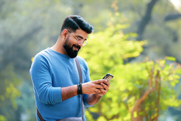 Indian man using smartphone at park
