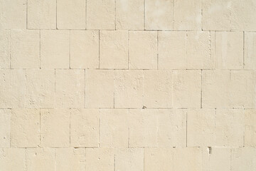 Naklejka premium Background with a stone wall made of large blocks painted with beige paint