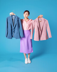 Image of young Asian businesswoman choosing clothes