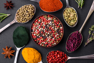 Variation of spices in metal spoons paprika, turmeric, cardamom, a mixture of allspice, thyme and rosemary