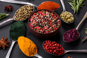 Variation of spices in metal spoons paprika, turmeric, cardamom, a mixture of allspice, thyme and rosemary