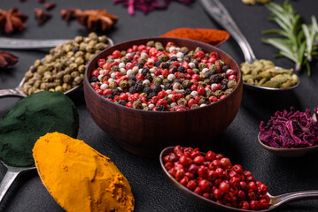 Variation of spices in metal spoons paprika, turmeric, cardamom, a mixture of allspice, thyme and rosemary
