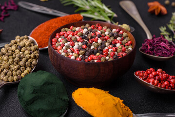 Variation of spices in metal spoons paprika, turmeric, cardamom, a mixture of allspice, thyme and rosemary